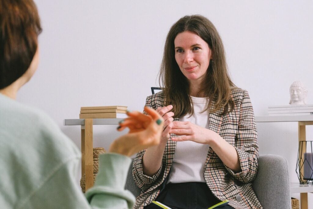 A mindfulness coach listens with an attentive expression, creating a safe space for a client to share.