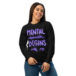 Smiling woman modeling a black long-sleeve t-shirt featuring the empowering quote 'Mental health BEGINS with me'.