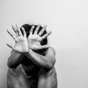 A man with his hands covering his face