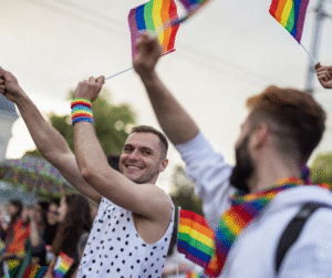 A group of men proudly holding vibrant rainbow flags