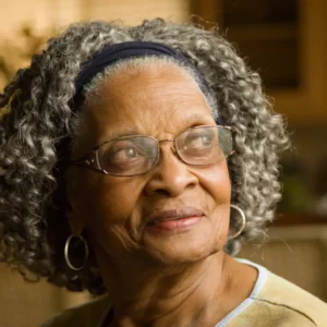 An older woman wearing glasses and a headband