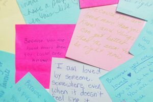 A colorful pile of post-it notes featuring various handwritten notes in different colors and sizes.