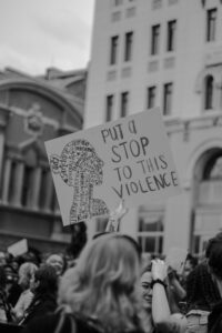 A woman holds a sign reading "Put a stop to this violence