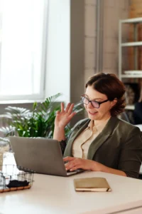 A woman wearing glasses sits at a desk