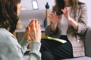 Two women sitting on a couch engaged in a conversation