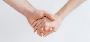 A couple holding hands against a plain white background