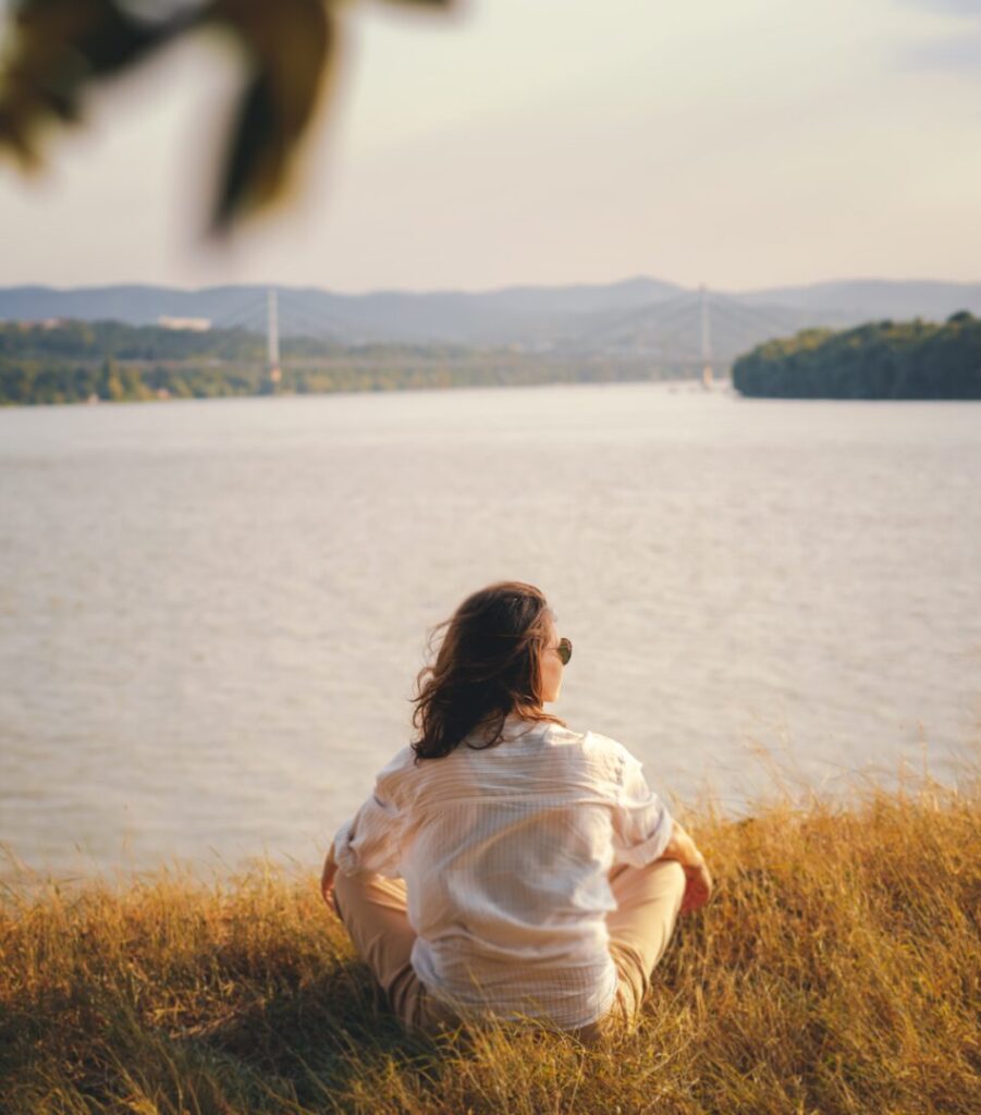 Woman sitting next to Ohio River feeling calm after therapy