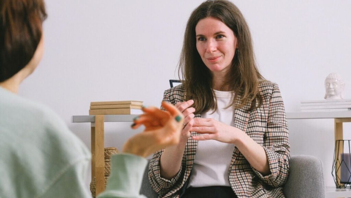 A mindfulness coach listens with an attentive expression, creating a safe space for a client to share.