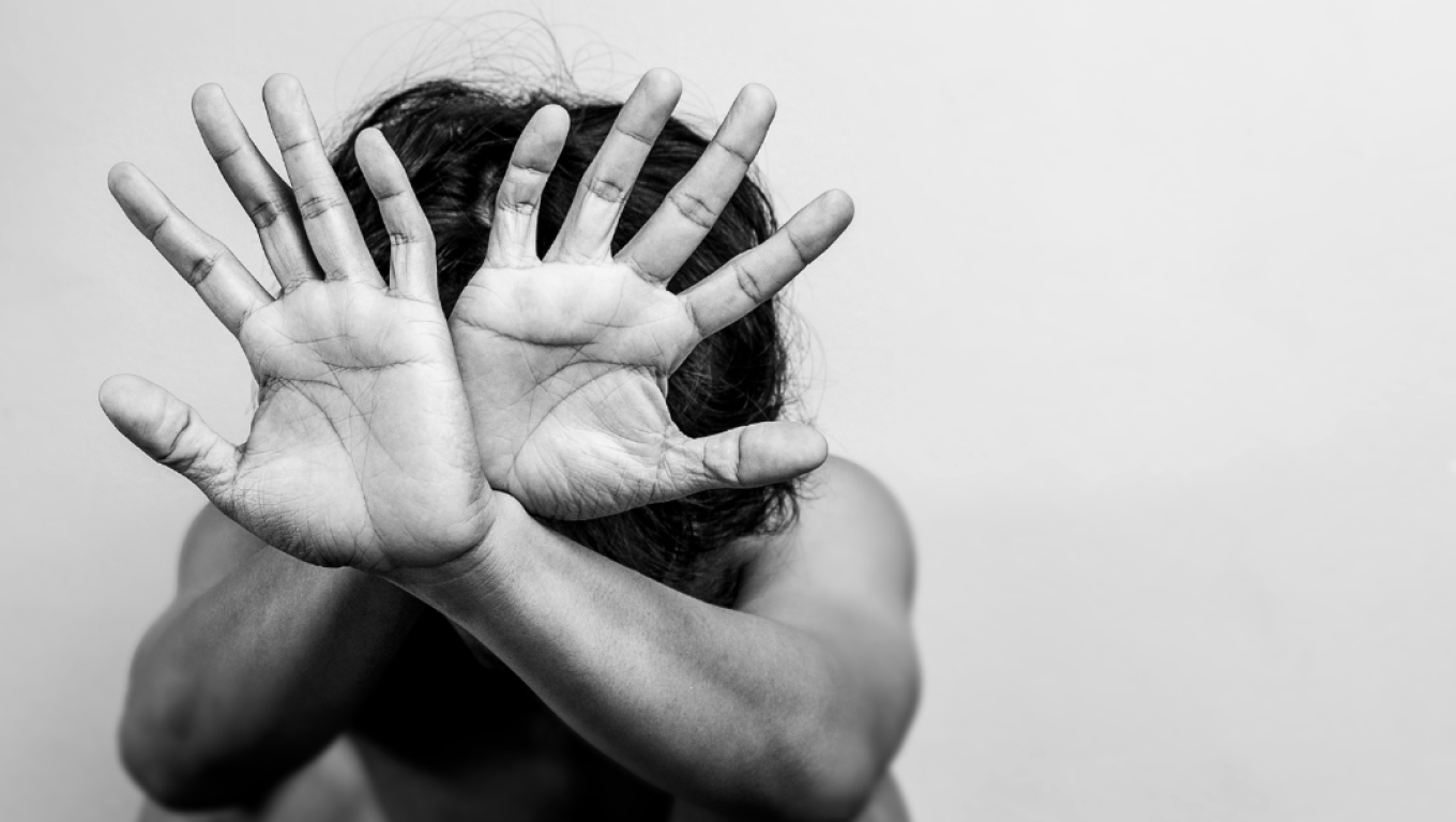 A man with his hands covering his face