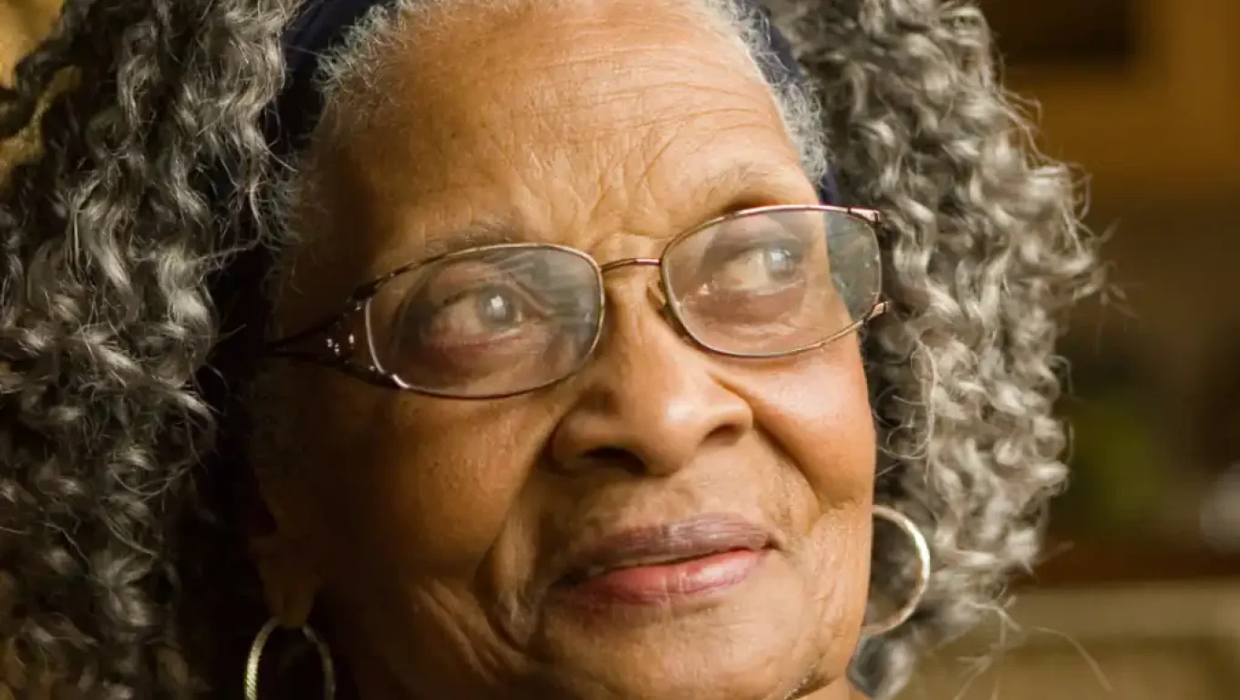 An older woman wearing glasses and a headband