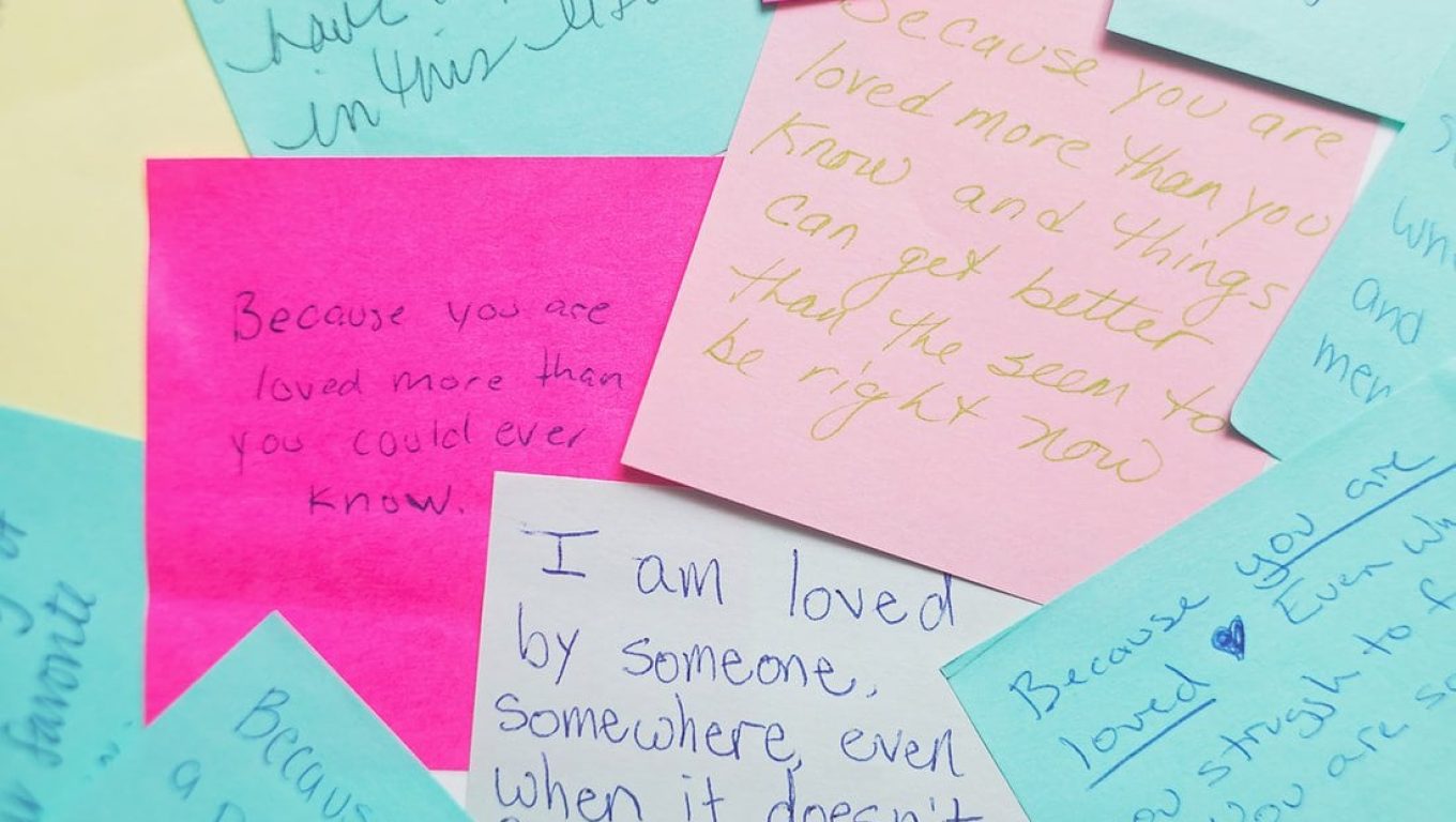 A colorful pile of post-it notes featuring various handwritten notes in different colors and sizes.