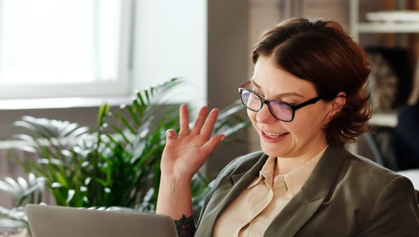A woman wearing glasses sits at a desk