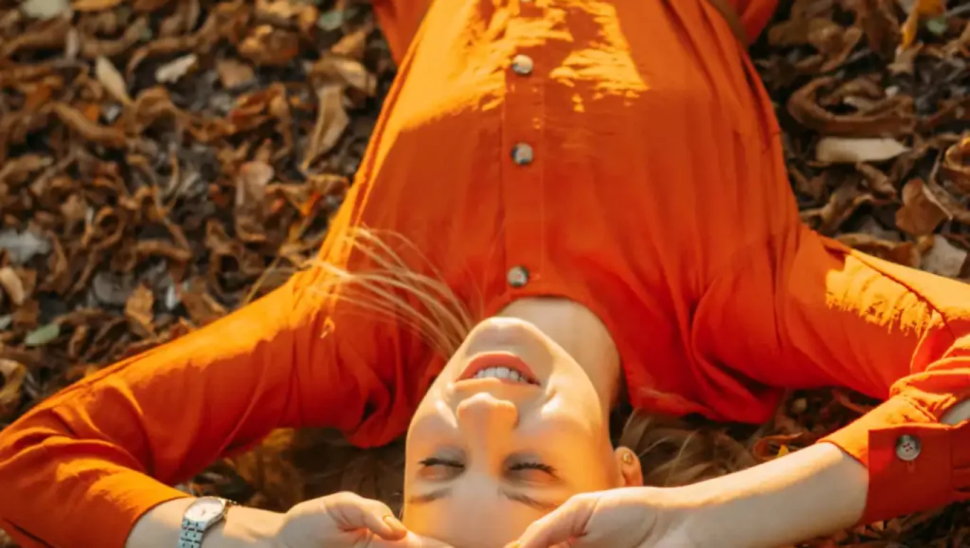 Person enjoying fall self-care activities like cozy reading and warm beverages.